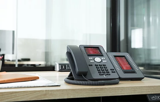 An Avaya J100 IP phone on a desk