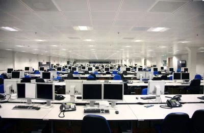 Landscape view of call centre with computers, phones and headsets
